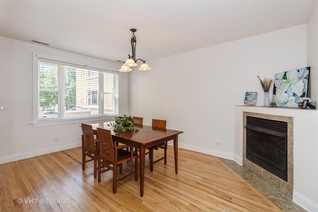 5416 W Windsor Ave Unit 1N, Chicago, IL 60630 - dining area featuring light wood-type flooring, a chandelier, and a tile fireplace