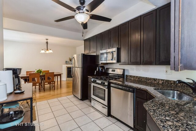 5416 W Windsor Ave Unit 1N, Chicago, IL 60630 - kitchen featuring stainless steel appliances, ceiling fan, dark brown cabinetry, dark stone counters, and pendant lighting
