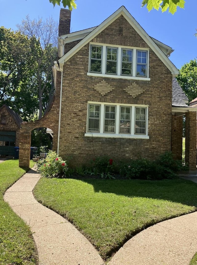 1334 Chestnut St, Waukegan, IL 60085 - view of home's exterior with brick siding, a chimney, and a lawn