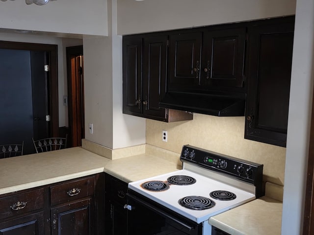 2117 11th St, Peru, IL 61354 - kitchen featuring range with electric cooktop, ventilation hood, light countertops, decorative backsplash, and dark cabinetry