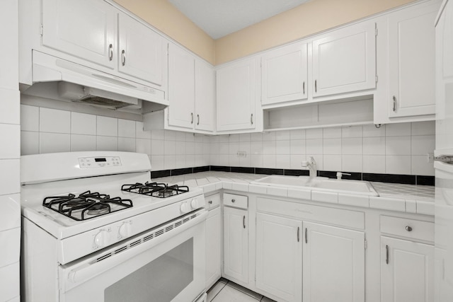 7234 W N Ave Unit 1610, Elmwood Park, IL 60707 - kitchen featuring gas range gas stove, tile counters, under cabinet range hood, and white cabinets