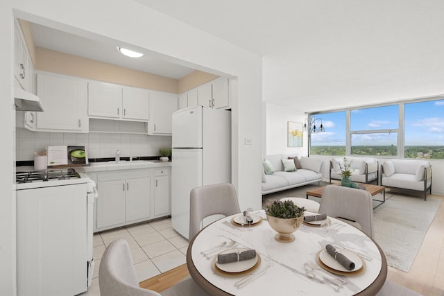 7234 W N Ave Unit 1610, Elmwood Park, IL 60707 - kitchen featuring white appliances, under cabinet range hood, open floor plan, white cabinetry, and backsplash
