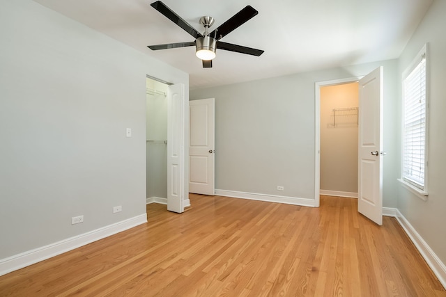 5641 W Carmen Ave, Chicago, IL 60630 - unfurnished bedroom with a spacious closet, a closet, multiple windows, and light wood-style floors