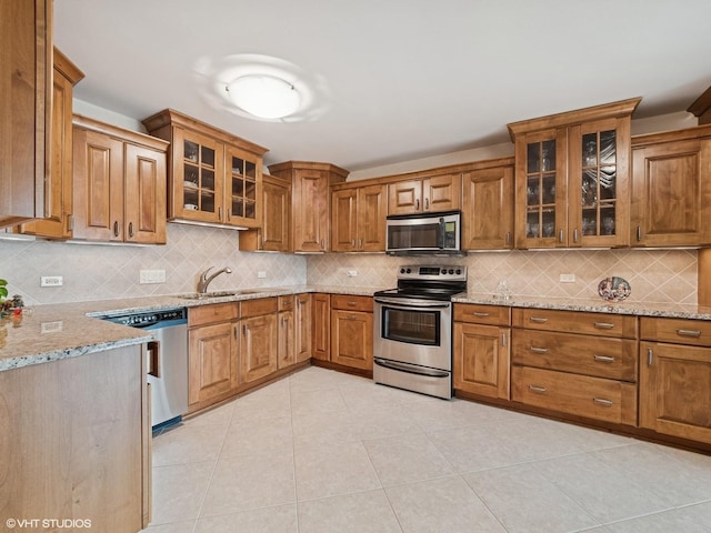 1671 Mission Hills Rd Unit 308, Northbrook, IL 60062 - kitchen with stainless steel appliances, brown cabinetry, and light stone countertops