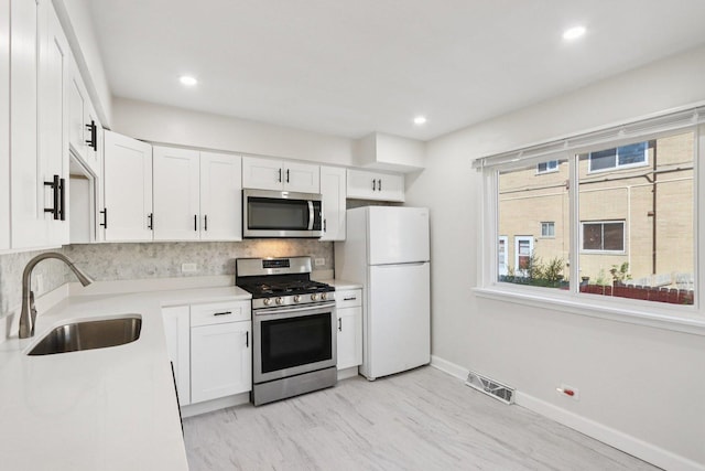 8666 Gregory Ln Unit C, Des Plaines, IL 60016 - kitchen with appliances with stainless steel finishes, decorative backsplash, white cabinetry, healthy amount of natural light, and recessed lighting