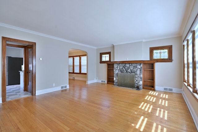3218 Scoville Ave, Berwyn, IL 60402 - unfurnished living room with light wood-style floors, plenty of natural light, arched walkways, a fireplace, and crown molding