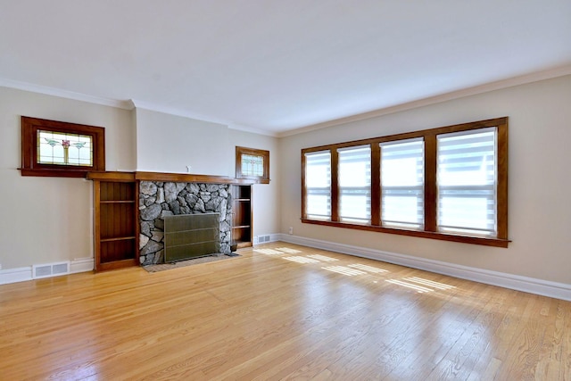 3218 Scoville Ave, Berwyn, IL 60402 - unfurnished living room featuring light wood-type flooring, a stone fireplace, and crown molding