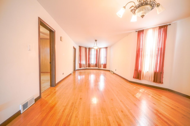 4048 N Marmora Ave, Chicago, IL 60630 - empty room featuring light wood-style floors and a chandelier