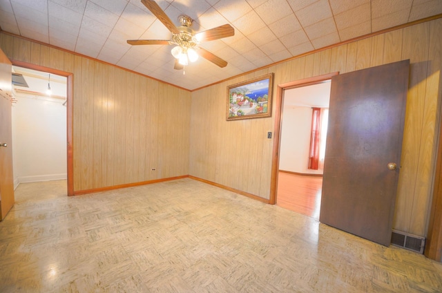 4048 N Marmora Ave, Chicago, IL 60630 - unfurnished room featuring a ceiling fan, wood walls, and ornamental molding