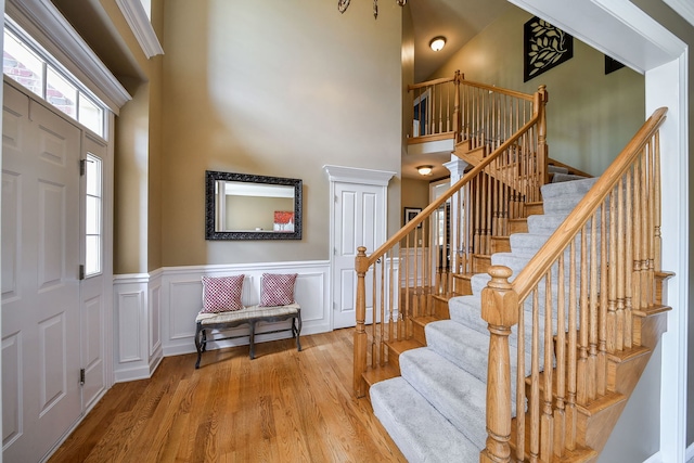 520 Meadowwood Ln, Oswego, IL 60543 - entryway with a towering ceiling, wood finished floors, stairs, and wainscoting