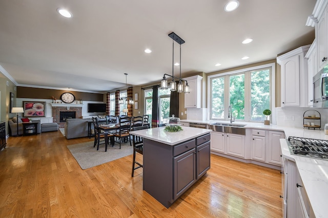 520 Meadowwood Ln, Oswego, IL 60543 - kitchen with white cabinetry, a kitchen breakfast bar, light wood-type flooring, pendant lighting, and recessed lighting