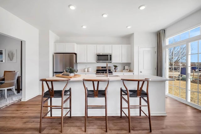 283 Charlestowne Lakes Dr, Saint Charles, IL 60174 - kitchen with stainless steel appliances, a center island with sink, light countertops, white cabinets, and recessed lighting