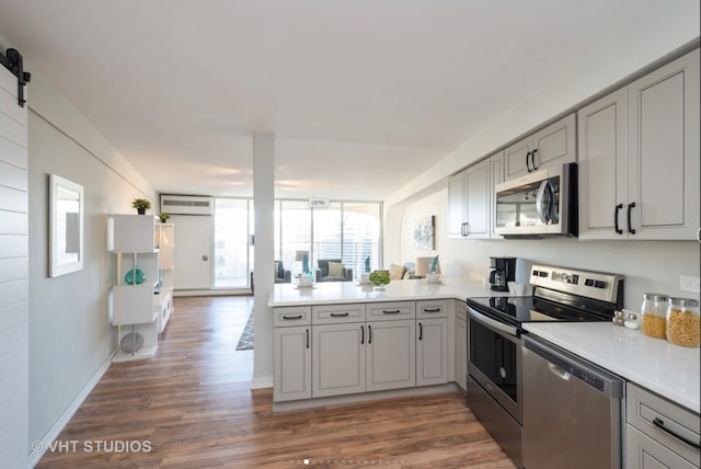 300 N State St Unit 3808, Chicago, IL 60654 - kitchen with stainless steel appliances, gray cabinets, a peninsula, dark wood finished floors, and light countertops