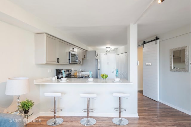300 N State St Unit 3808, Chicago, IL 60654 - kitchen featuring stainless steel microwave, a barn door, stove, light countertops, and a breakfast bar