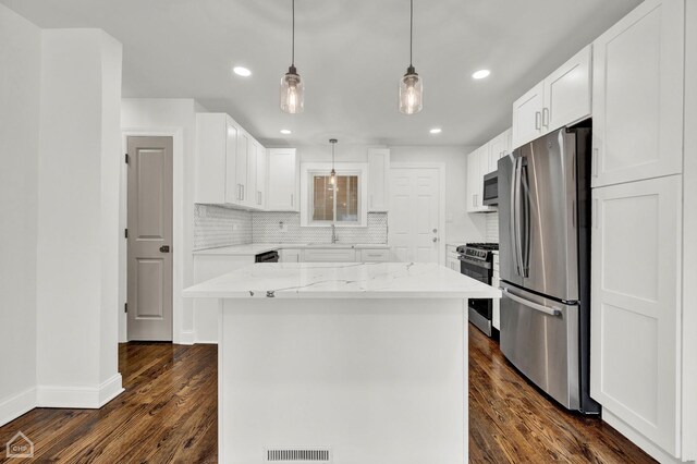 8559 S Drexel Ave, Chicago, IL 60619 - kitchen featuring appliances with stainless steel finishes, light stone counters, decorative backsplash, dark wood-type flooring, and recessed lighting
