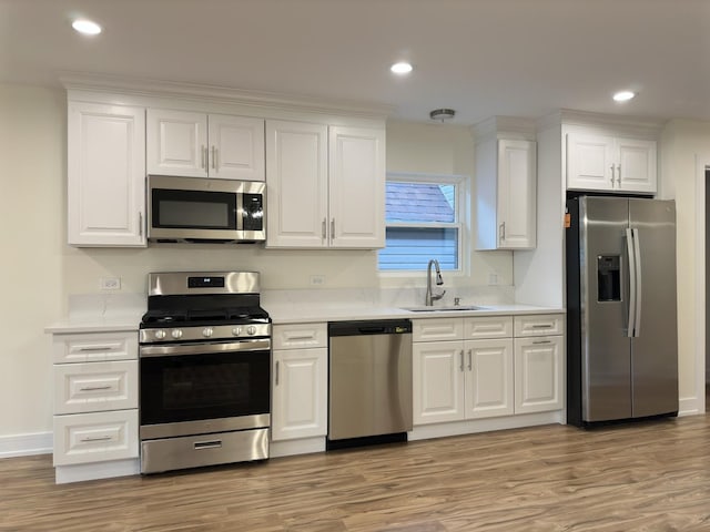 1325 S 50th Ct, Cicero, IL 60804 - kitchen featuring appliances with stainless steel finishes, light countertops, light wood-style flooring, white cabinetry, and recessed lighting