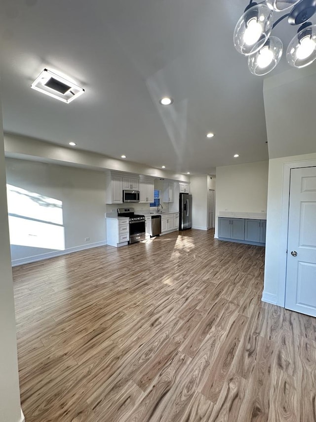 1325 S 50th Ct, Cicero, IL 60804 - unfurnished living room featuring light wood-style floors, recessed lighting, and a chandelier