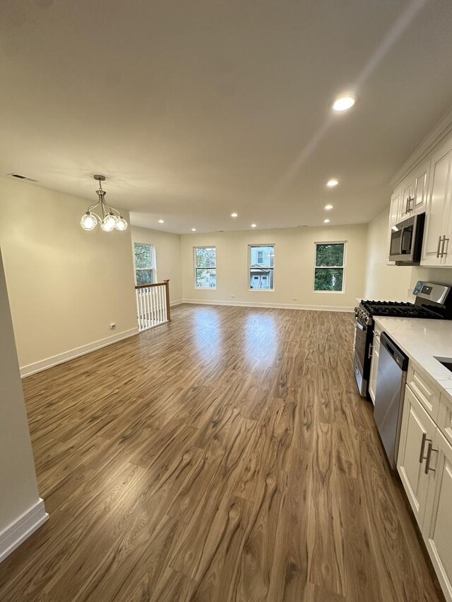 1325 S 50th Ct, Cicero, IL 60804 - kitchen featuring appliances with stainless steel finishes, a chandelier, white cabinetry, dark wood-type flooring, and recessed lighting