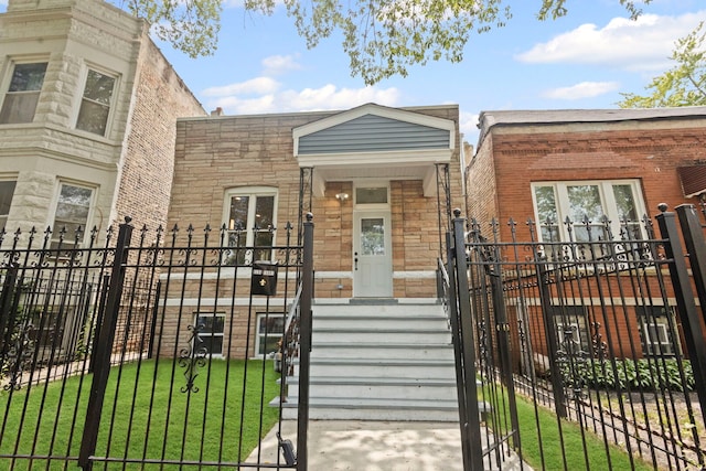 4025 W Adams St, Chicago, IL 60624 - view of front facade featuring stone siding, a fenced front yard, and a gate