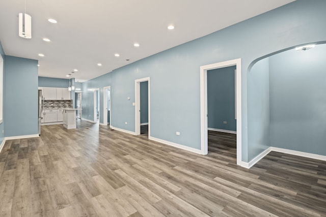 4025 W Adams St, Chicago, IL 60624 - unfurnished living room with arched walkways, light wood-type flooring, and recessed lighting