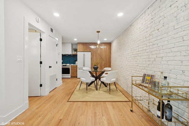 636 W Buckingham Pl Unit C, Chicago, IL 60657 - dining space with light wood-style floors, recessed lighting, brick wall, and a chandelier