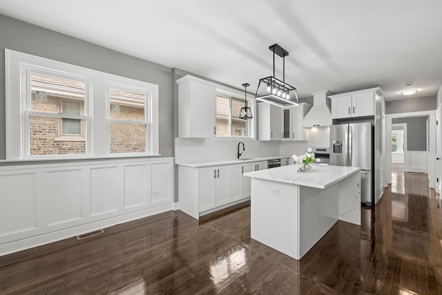 2107 E Ave, Berwyn, IL 60402 - kitchen with stainless steel refrigerator with ice dispenser, custom exhaust hood, a center island, white cabinetry, and wainscoting