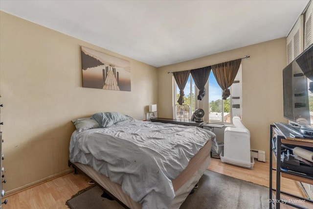 1227 S Harlem Ave Unit 514, Berwyn, IL 60402 - bedroom featuring wood finished floors and a baseboard radiator