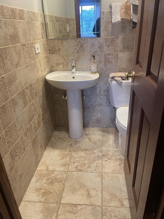 1017 Buccaneer Dr Unit 5, Schaumburg, IL 60173 - half bathroom with tile walls, wainscoting, and stone finish flooring