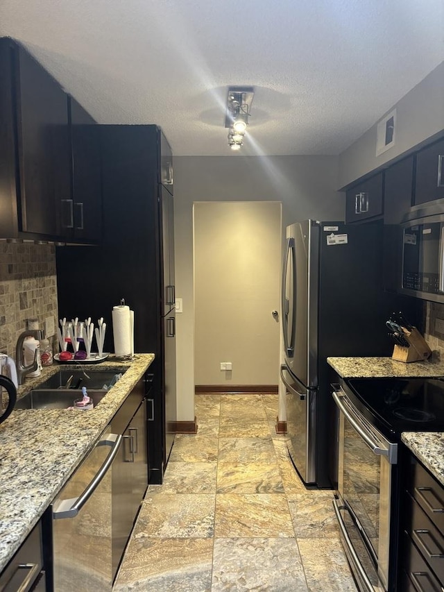 1017 Buccaneer Dr Unit 5, Schaumburg, IL 60173 - kitchen with appliances with stainless steel finishes, decorative backsplash, a ceiling fan, light stone countertops, and a textured ceiling