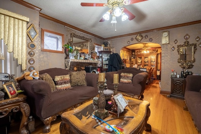 4830 W Oakdale Ave, Chicago, IL 60641 - living area featuring arched walkways, ceiling fan, wood finished floors, wallpapered walls, and crown molding