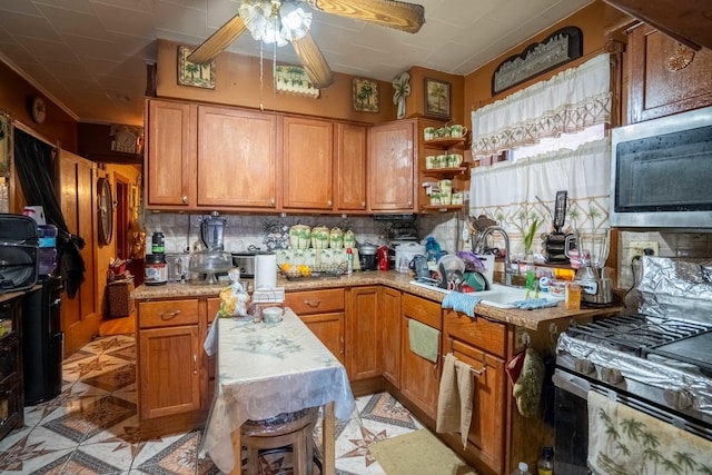 4830 W Oakdale Ave, Chicago, IL 60641 - kitchen with stainless steel microwave, light countertops, a ceiling fan, range with gas cooktop, and decorative backsplash