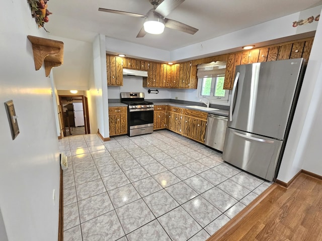 611 Kungs Way, Joliet, IL 60435 - kitchen with stainless steel appliances, brown cabinetry, under cabinet range hood, ceiling fan, and dark countertops