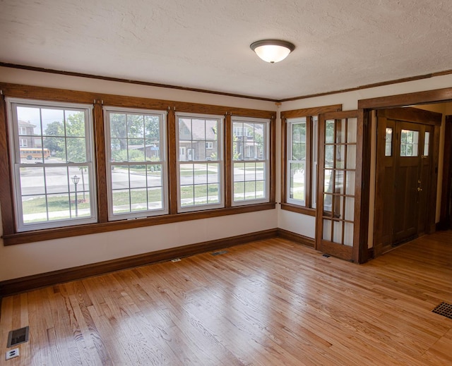 224 N Maple St, Gilman, IL 60938 - spare room featuring a textured ceiling, light wood finished floors, and crown molding