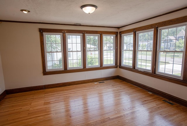 224 N Maple St, Gilman, IL 60938 - empty room with light wood-type flooring, crown molding, and a textured ceiling