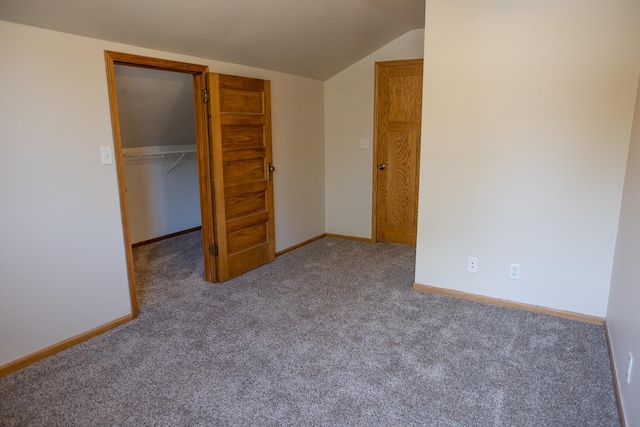 224 N Maple St, Gilman, IL 60938 - unfurnished bedroom with carpet floors, lofted ceiling, a closet, and a walk in closet