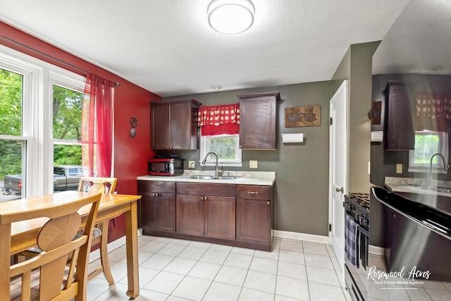 382 N 8th Ave, Kankakee, IL 60901 - kitchen featuring light countertops, healthy amount of natural light, light tile patterned floors, a textured ceiling, and gas range oven