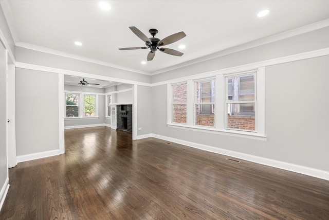 unfurnished living room featuring ceiling fan, a fireplace, dark wood finished floors, recessed lighting, and ornamental molding