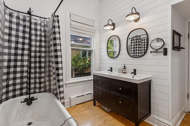 1422 Wesley Ave, Evanston, IL 60201 - full bathroom featuring baseboard heating, a freestanding bath, wood finished floors, wooden walls, and double vanity