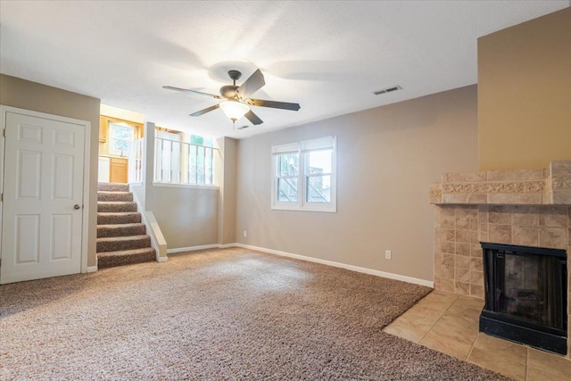 6 Starlight Ct, Bloomington, IL 61704 - unfurnished living room with carpet flooring, stairs, a ceiling fan, and a tiled fireplace