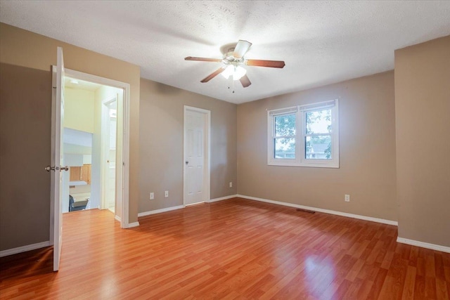 6 Starlight Ct, Bloomington, IL 61704 - unfurnished bedroom with light wood-type flooring, a textured ceiling, a ceiling fan, and ensuite bath