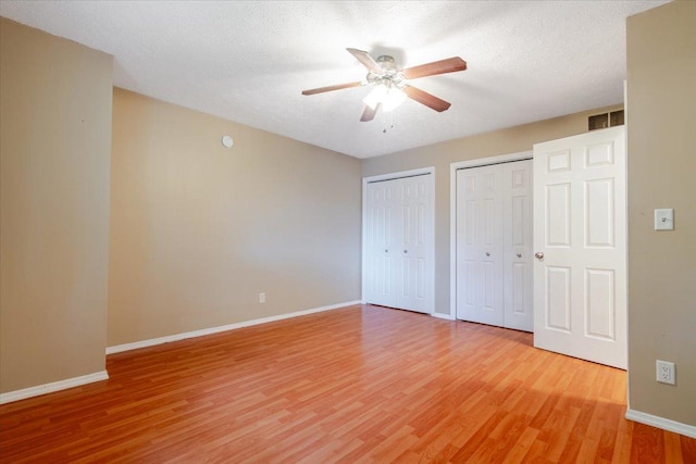 6 Starlight Ct, Bloomington, IL 61704 - unfurnished bedroom with two closets, light wood finished floors, and ceiling fan