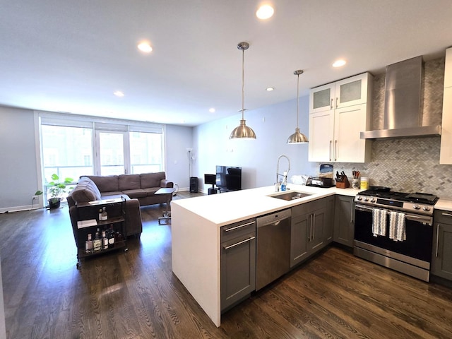 2744 N Lincoln Ave Unit 2, Chicago, IL 60614 - kitchen featuring stainless steel appliances, wall chimney exhaust hood, a peninsula, dark wood-type flooring, and light countertops