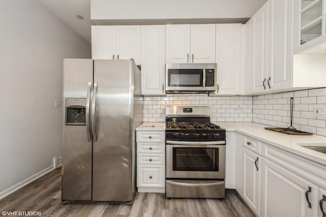 3252 S Prairie Ave Unit 2S, Chicago, IL 60616 - kitchen featuring appliances with stainless steel finishes, white cabinetry, light countertops, and decorative backsplash