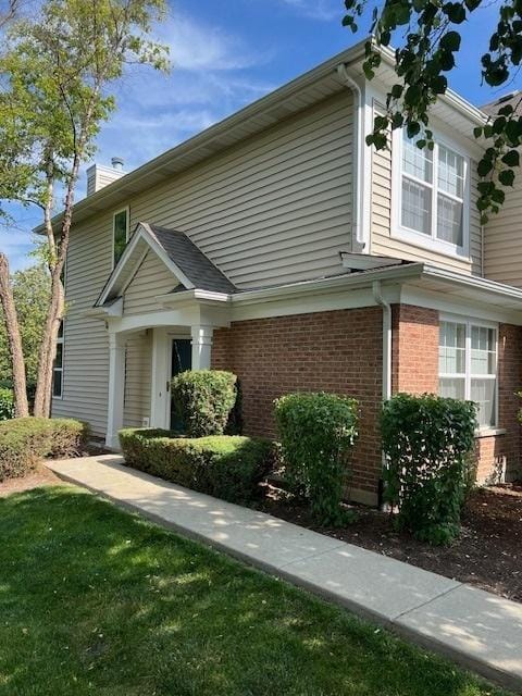 372 S Crown Ct, Palatine, IL 60074 - view of home's exterior featuring brick siding, a chimney, and a lawn