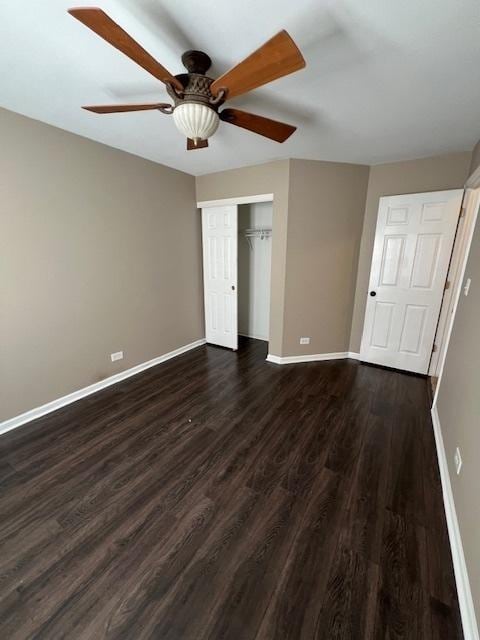 372 S Crown Ct, Palatine, IL 60074 - unfurnished bedroom with dark wood-style flooring, a closet, and a ceiling fan
