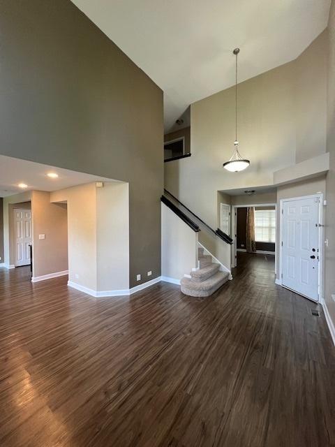 372 S Crown Ct, Palatine, IL 60074 - unfurnished living room with a towering ceiling, dark wood finished floors, and stairs