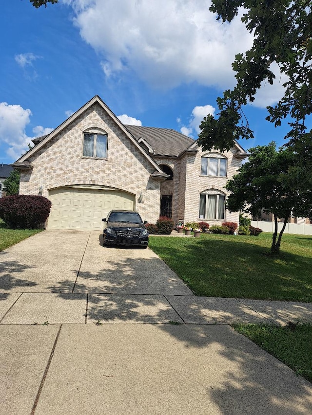 3806 Carrington Dr, Hazel Crest, IL 60429 - french country style house featuring driveway, a front lawn, an attached garage, and brick siding