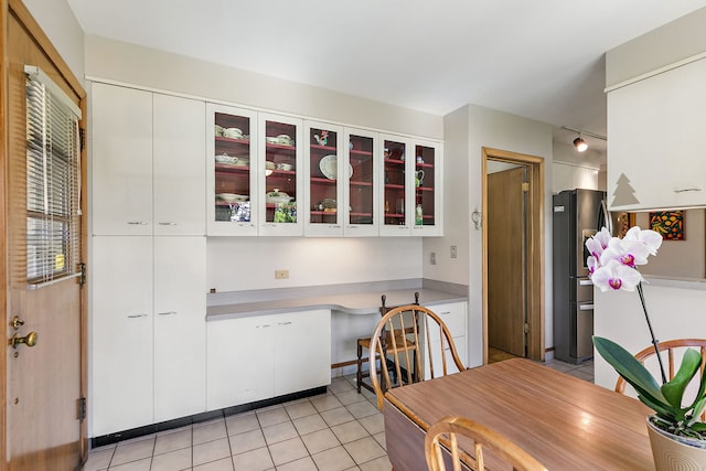 306 Wing Park Blvd, Elgin, IL 60123 - kitchen featuring light tile patterned floors, white cabinets, light countertops, glass insert cabinets, and freestanding refrigerator