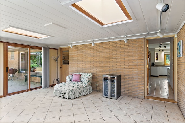 306 Wing Park Blvd, Elgin, IL 60123 - sitting room featuring rail lighting, brick wall, beverage cooler, a skylight, and light tile patterned floors