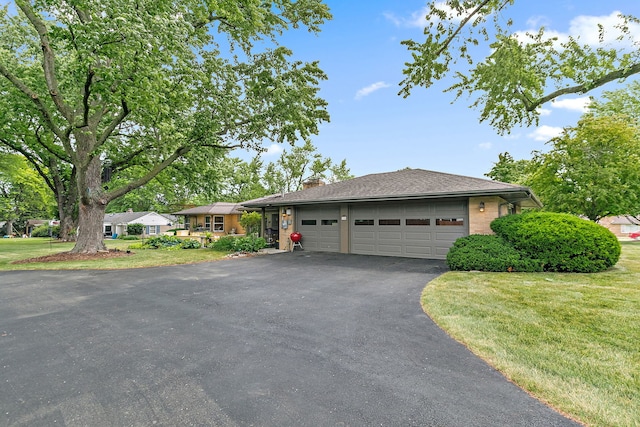 306 Wing Park Blvd, Elgin, IL 60123 - single story home featuring asphalt driveway, an attached garage, a chimney, and a front lawn